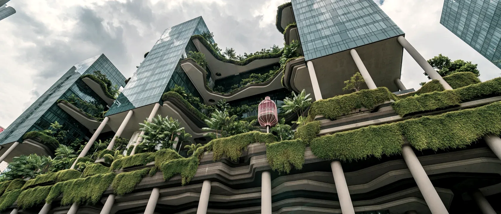 Glass towers rising from densely planted concrete terraces at the Parkroyal Collection Pickering in Singapore